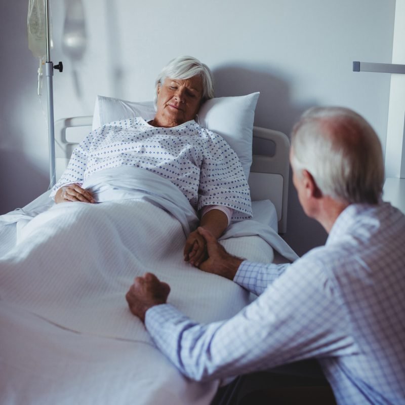 ill-woman-sleeping-bed-while-worried-man-sitting-beside-her-bed_107420-63862